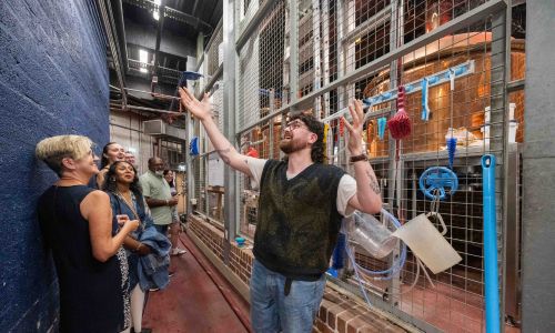 A man shows a group the brewery facilities