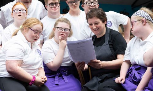 a group of young adults and chef at a kitchen take over event as part of cork on a fork