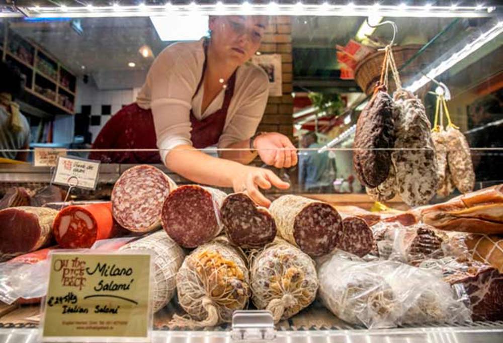 Worker arranging a salami selection