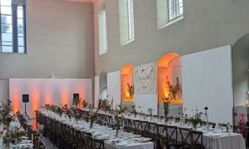 Set white cloth dinner long tables at St Peter's Church Cork
